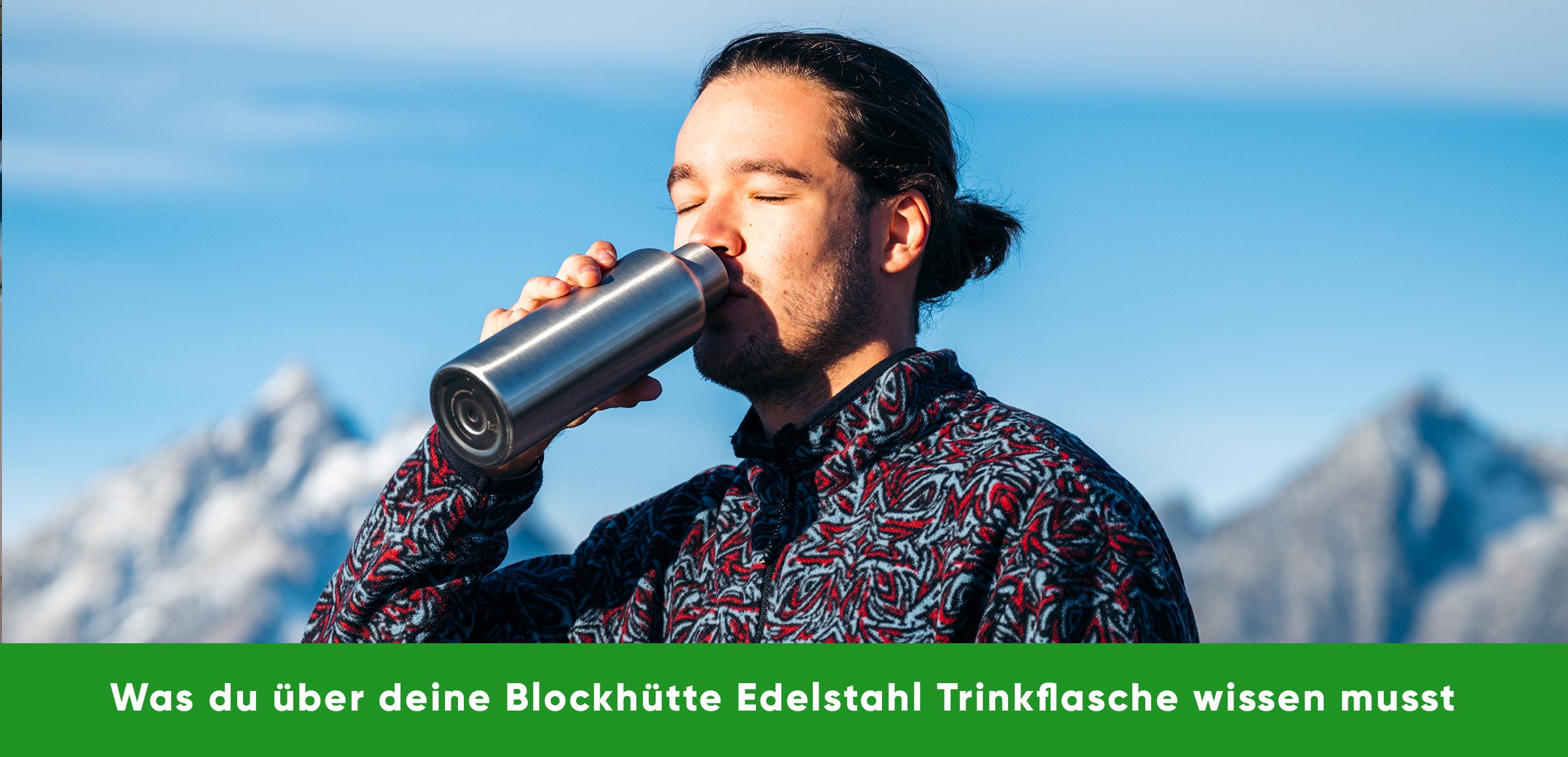 Ein junger Man trinkt aus der Blockhütte Edelstahl Trinkflasche vor einem Bergpanorame